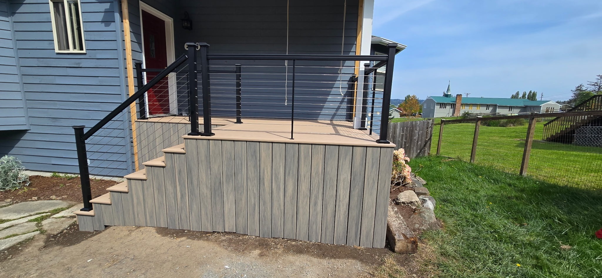 Side view of composite front porch with skirting and railing